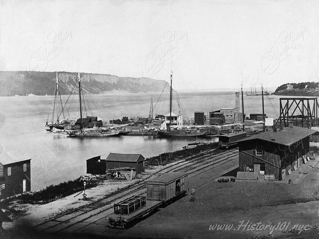 A view overlooking the Palisades, Hudson and Yonkers dockyard with railroad tracks which ran parallel to the Hudson River. Taken by Silas A. Holmes in 1855.