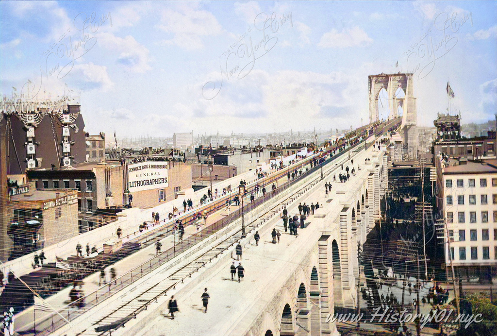 Photo by Theodore Gubelman presents a view of the Brooklyn Bridge overpass, teeming with a multitude of pedestrians against the backdrop of Brooklyn in the distance.